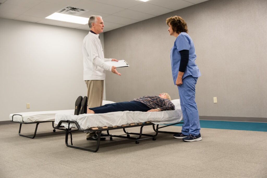 Doctor, nurse, and patient in a room - patient laying on cot